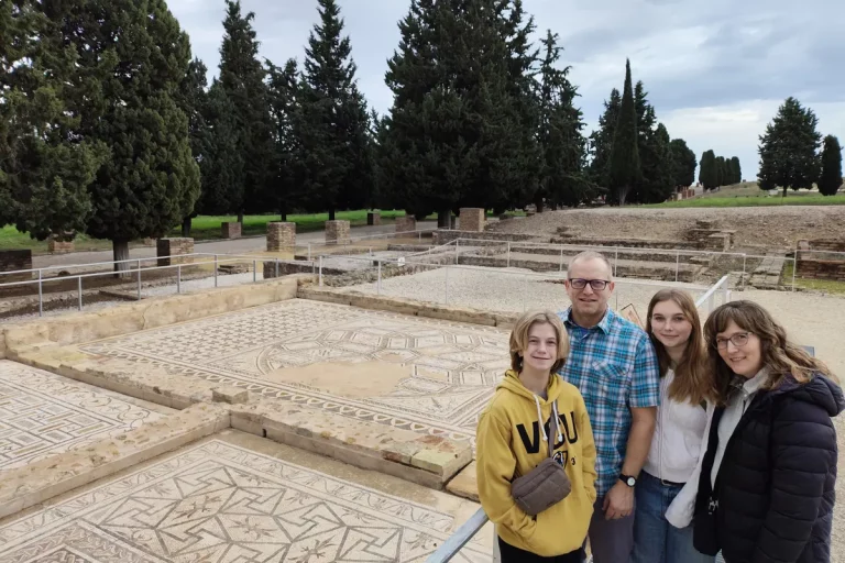 grupo posando delante mosaicos romanos visita guiada ciudad romana italica 768x512