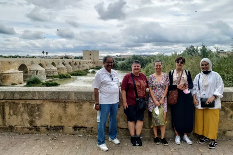 grupo posando delante puente romano cordoba visita guiada naturanda 1 768x512